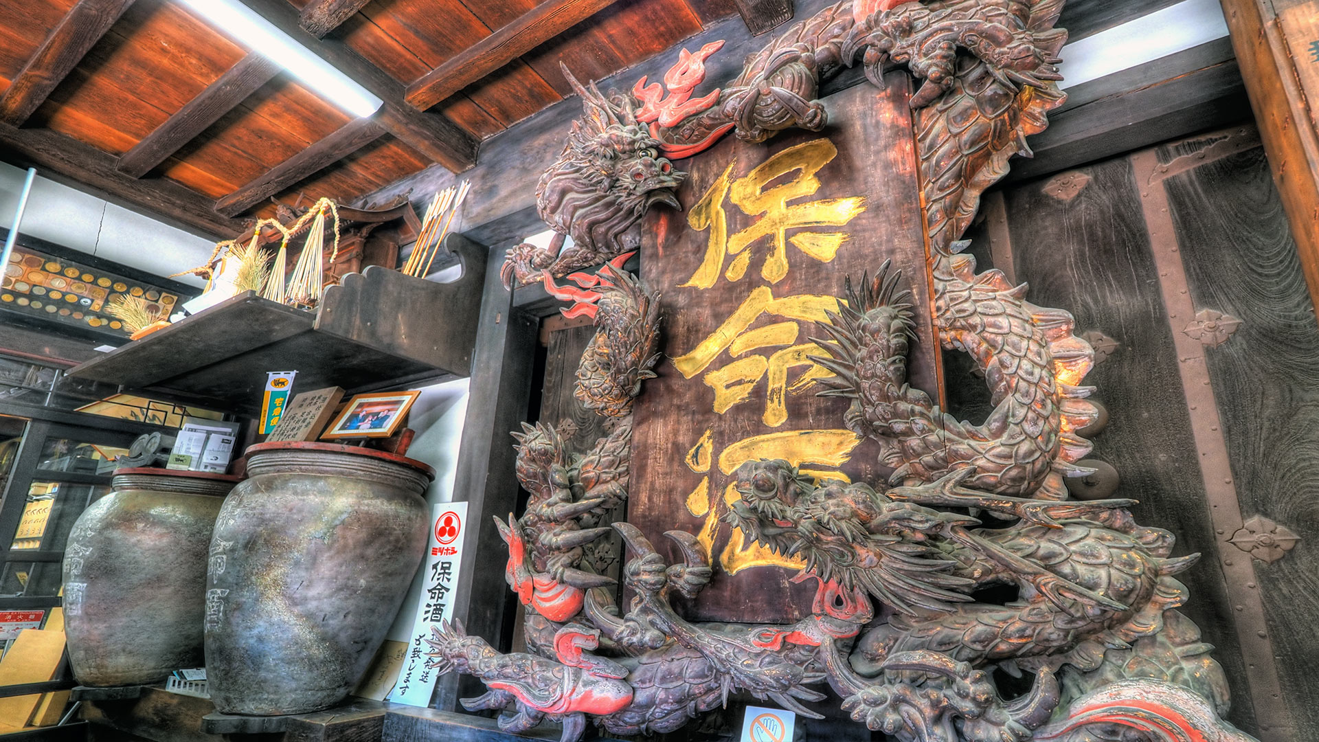 岡本亀太郎本店内に鎮座する『大きな龍の看板』と左手にある古備前の保命酒甕も、当時中村家から譲り受けた由緒ある品だそうです。